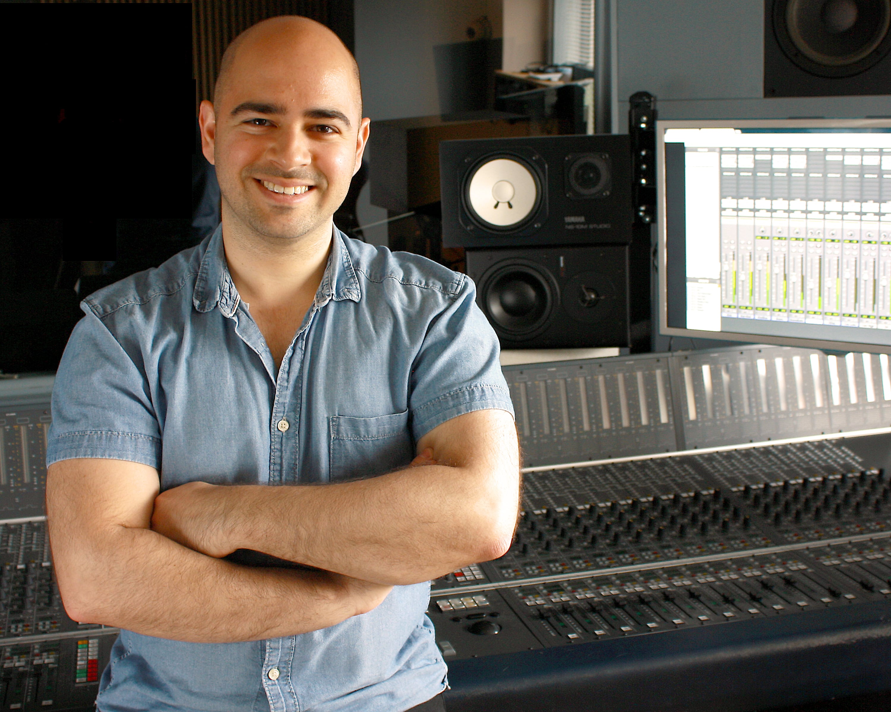 Mike Indovina in front of recording console and speakers